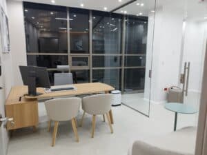 Oficina moderna con escritorio y sillas elegantes.