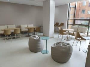 Sala de estar moderna con sillas y mesas.