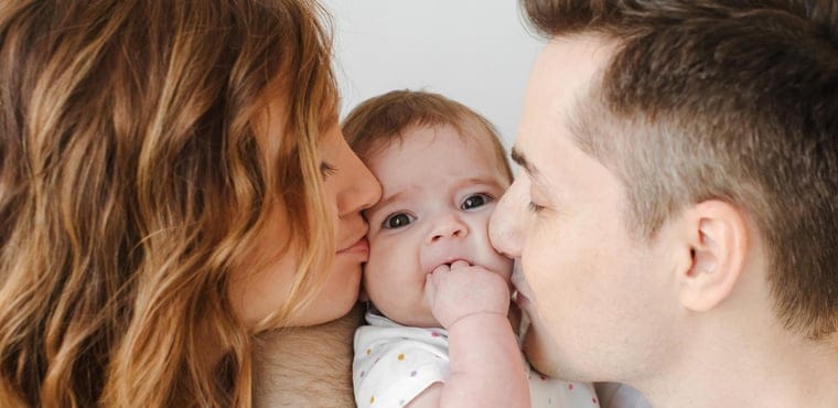 Padres besan a su bebé