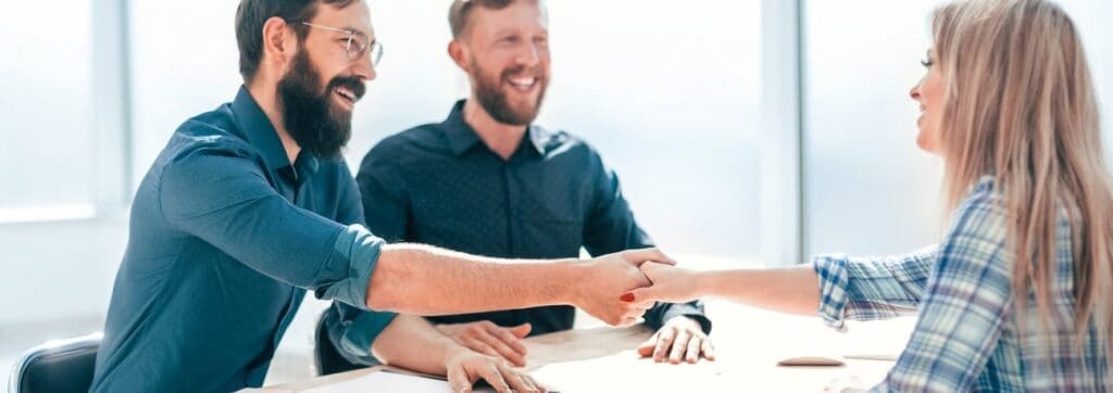 Personas estrechando manos en reunión amistosa.