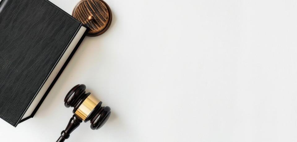 Martillo y libro de leyes en mesa blanca